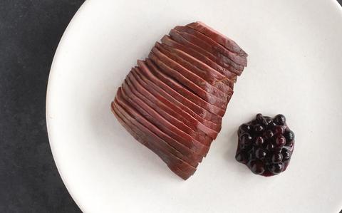 Schipholgans met saus van zwarte bessen.