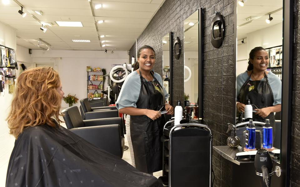 Ruta Tesfazgi knipt het haar van een klant in haar kapsalon aan de Nieuwestad in Leeuwarden.