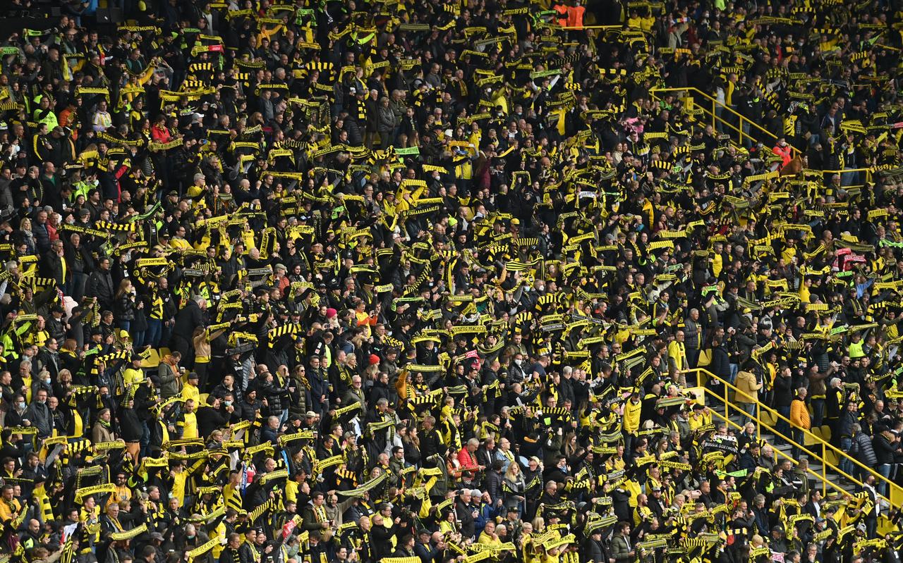 Een kaartje op de beroemde Gelbe Wand van Dortmund kost nog geen twintig euro. Tegen Ajax blijft het stadion gedeeltelijk leeg – een coronaprotest. Een kaartje op de beroemde Gelbe Wand van Dortmund kost nog geen twintig euro. Tegen Ajax blijft het stadion gedeeltelijk leeg – een coronaprotest.