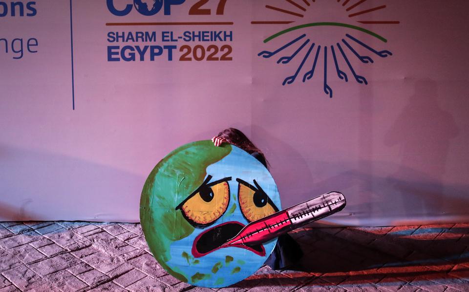 Een activist protesteert op de klimaattop in Egypte voor meer maatregelen om de opwarming van de aarde tegen te gaan. 