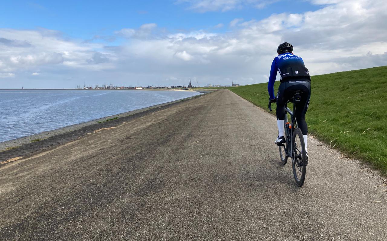 Buitendijks fietsen langs de Waddenzee, met in de verte de haven van Harlingen.