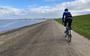 Buitendijks fietsen langs de Waddenzee, met in de verte de haven van Harlingen.