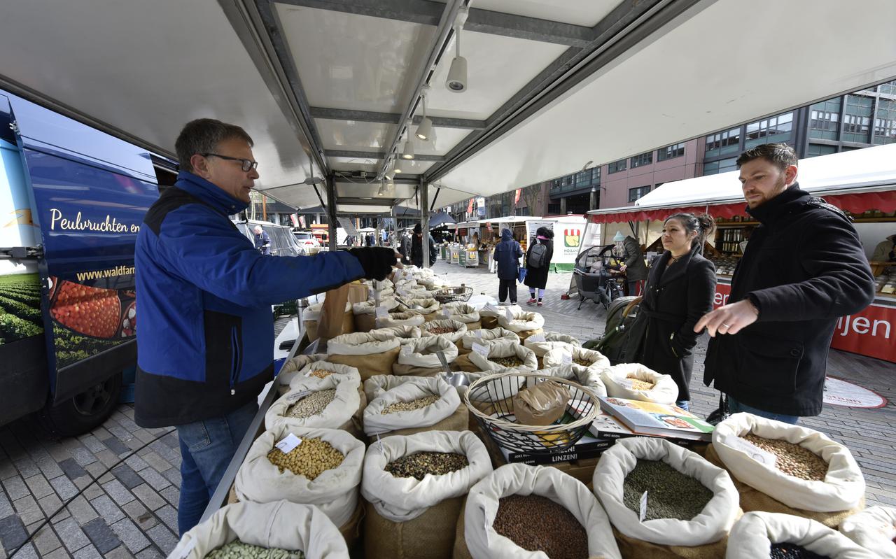 Henk Zuidema van Waldfarming uit Jistrum verkoopt peulvruchten op de weekmarkt in het centrum van Leeuwarden. 