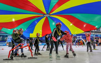 Dankzij een speciaal frame (links op de foto) is het voor kinderen die niet zelfstandig kunnen staan of bewegen mogelijk te schaatsen.