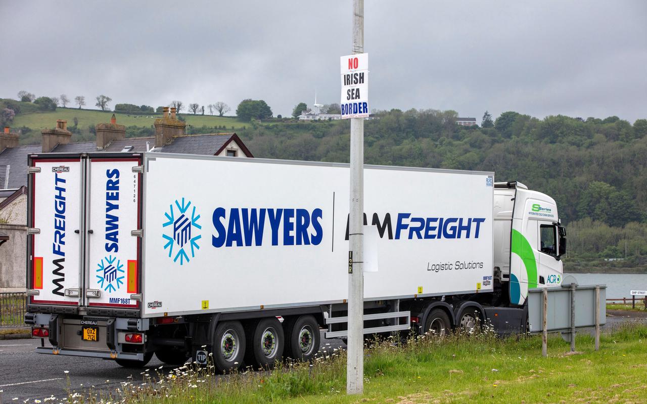 Een vrachtwagen rijdt langs een bord met de tekst 'No Irish Sea Border'.