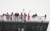 Een veerboot met de vlag half stok vertrekt uit de haven van Harlingen.