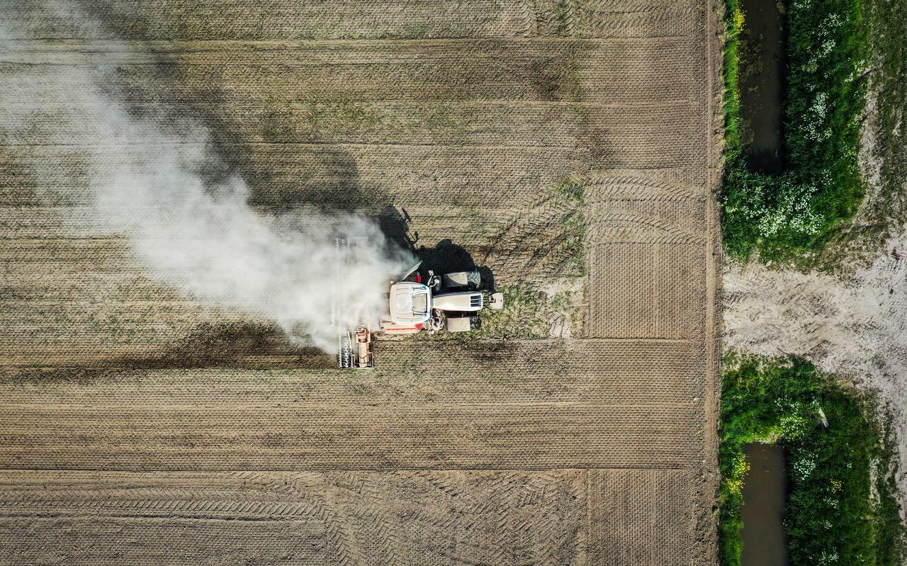 Dronefoto van een tractor die een droge akker in een polder bij Strijen bewerkt. Door de droogte groeit het gewas minder snel. Dronefoto van een tractor die een droge akker in een polder bij Strijen bewerkt. Door de droogte groeit het gewas minder snel.