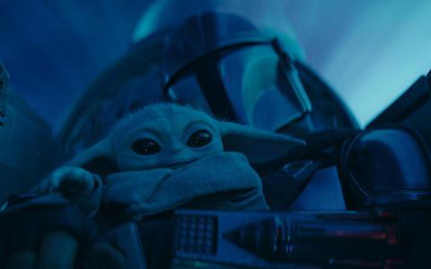 Grogu, beter bekend als Baby Yoda, op schoot van de Mando (Pedro Pascal) in het derde seizoen van ’The Mandalorian’.