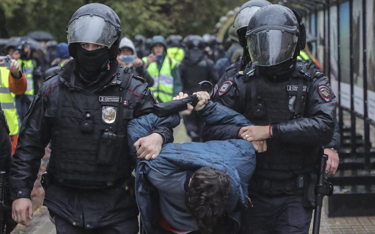 Russische politiemensen voeren een demonstrant tegen de mobilisatie af in Moskou.