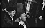 Jan Lever hangt Martin Luther King de ere-cappa om tijdens een senaatszitting van de Vrije Universiteit op 20 oktober 1965. 