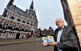 Theo Kuipers met het Franeker Woardeboek (Franekers-Nederlands [inclusief Fries, Bildts en Liwwadders] en Nederlands-Franekers), voor het oude stadhuis in Franeker.