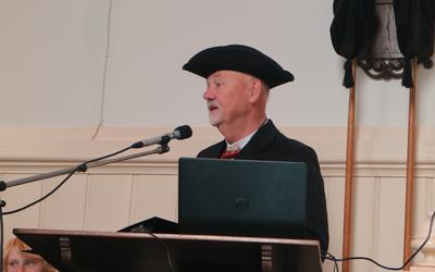 Voorzitter Gerrit Groeneveld spreekt - gehuld in Hindelooper kostuum - bij de afsluiting van Tsjerkepaad 2022