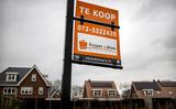 Een bord met te koop bij een woning. 