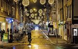 Een zo goed als lege met kerstverlichting versierde Haarlemmerstraat in de vroege avonduren in de Amsterdamse binnenstad. 