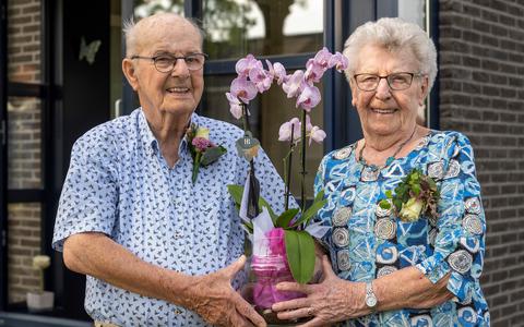 Jelte van Langen en Matty Wierda laten een bloemstuk zien dat ze kregen ter ere van hun 65-jarig huwelijksjubileum.