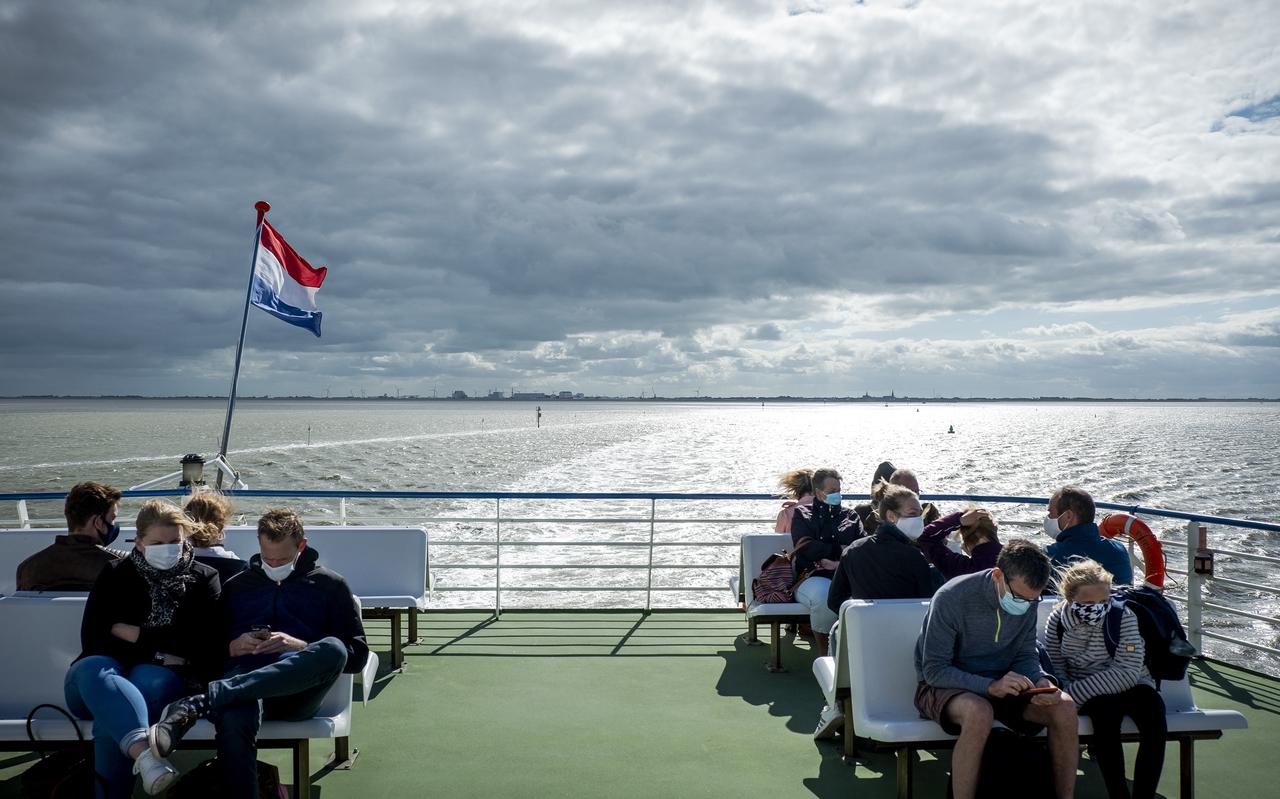 Vakantiegangers met mondkapjes op de veerboot van Rederij Doeksen naar Terschelling. 