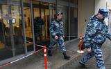 Russische agenten na een inval in een kantoorpand waarin de Kremlinkritische organisatie Open Rusland huist. 