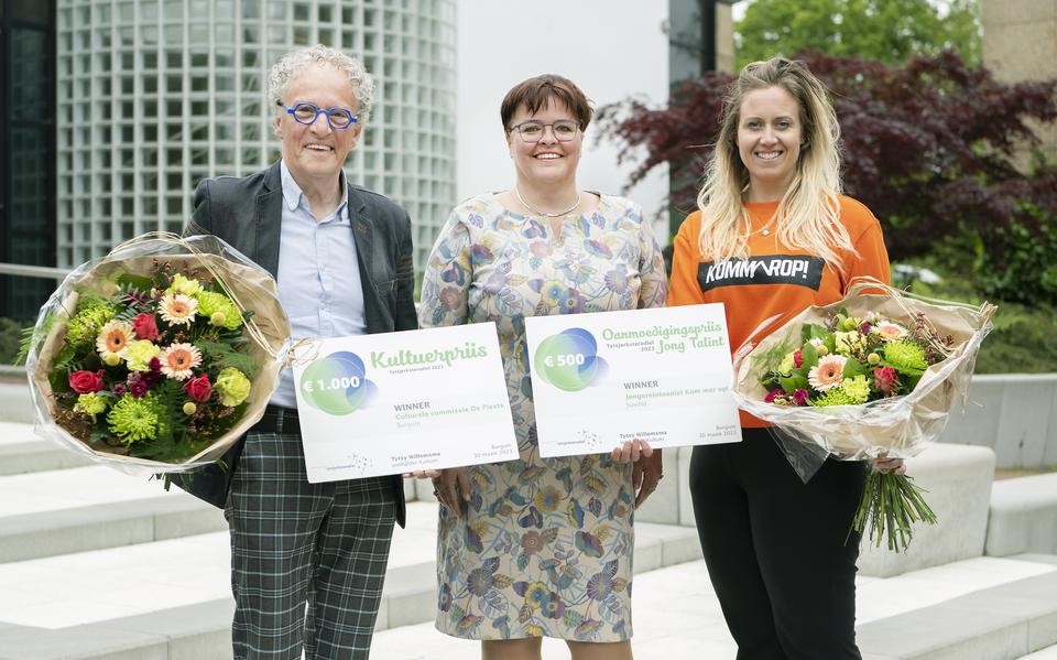 Piet Kuiper van De Pleats (links) en Mirjam Ros van Kom mar op! (rechts) nemen de prijzen aan van wethouder Tytsy Willemsma (midden).
