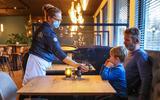 Esther Oud bedient Gerard Heerma en diens zoon Joas Heerma in restaurant Hof van de Koning op de eerste dag na de lockdown. 
