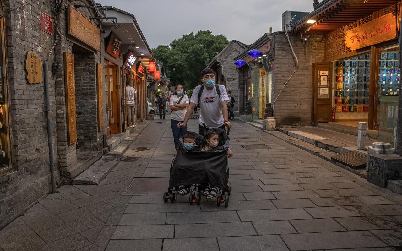 Een Chinese vader in Beijing met zijn twee kinderen. Sinds vorig jaar mogen Chinese echtparen drie kinderen krijgen. 