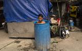 Een jongen zoekt verkoeling in een ton met water, in New Delhi. 