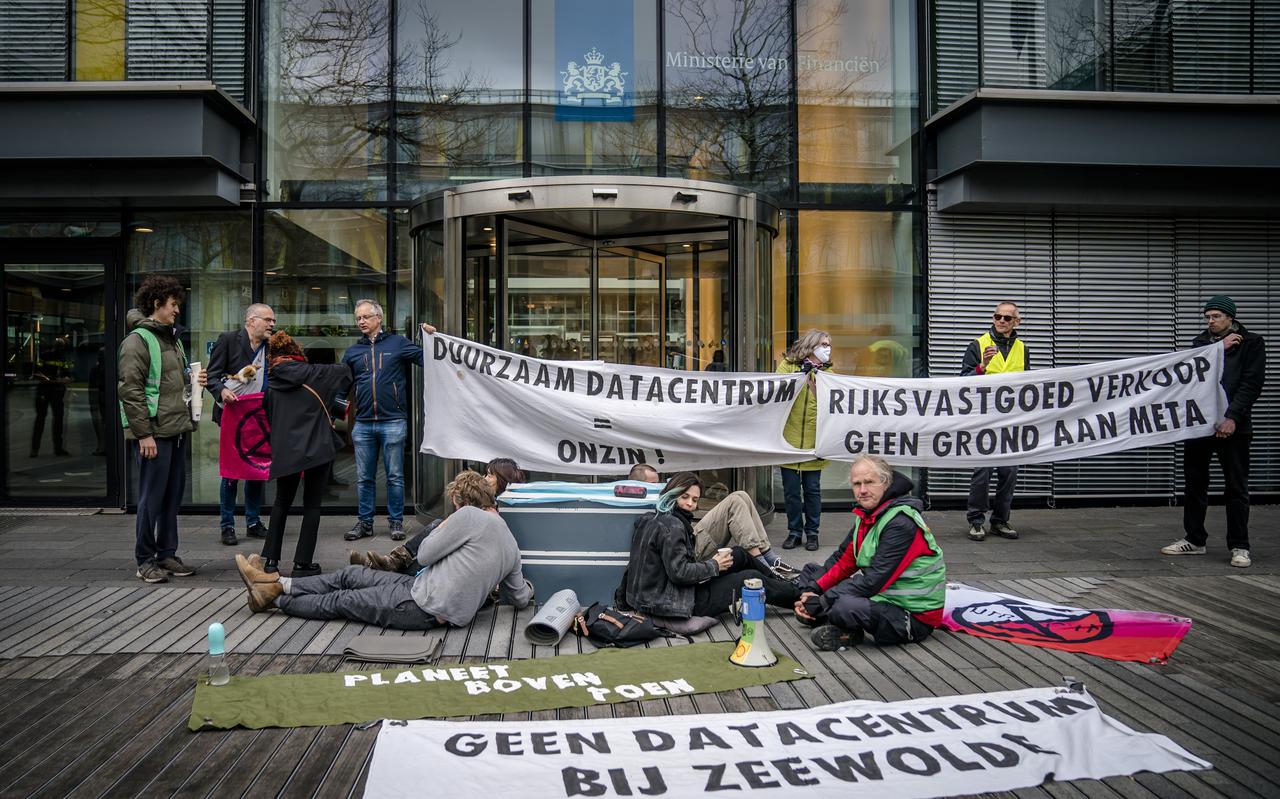 Actievoerders ketenen zich vast voor de deur van het Ministerie van Financien. De activisten eisen dat er geen datacentrum bij Zeewolde wordt gebouwd. 