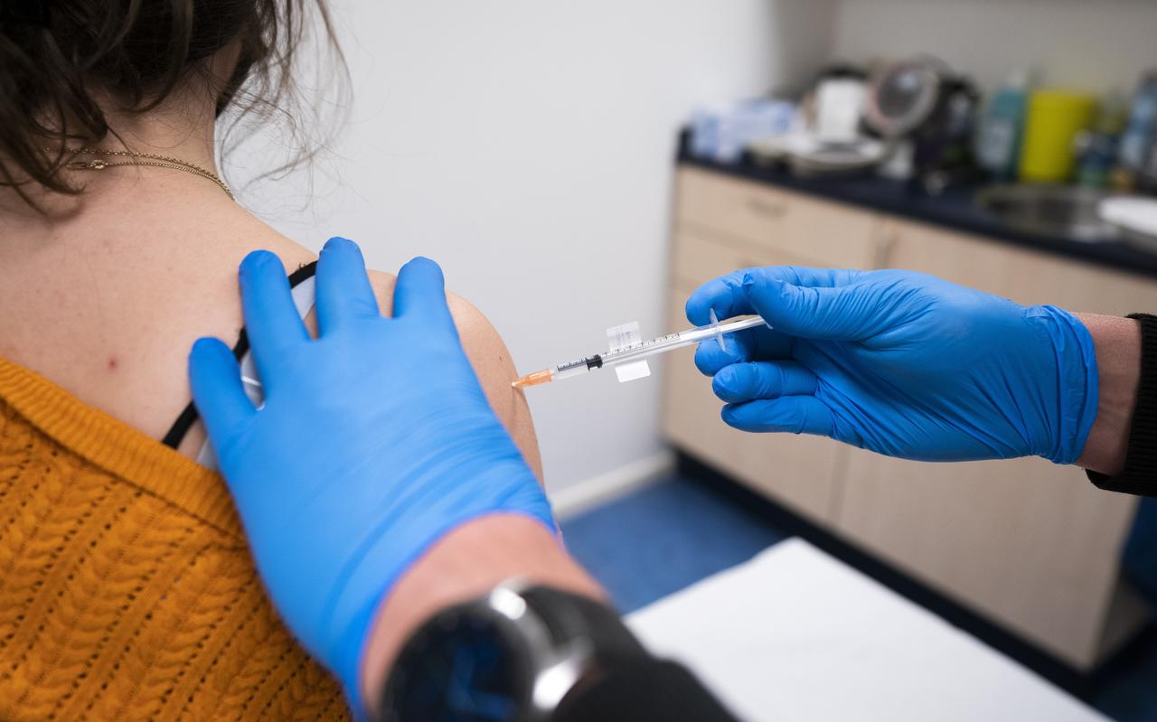 Een huisarts vaccineert een patiënt in zijn praktijk. Een huisarts vaccineert een patiënt in zijn praktijk.