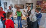 Klaas Weremeus Buning (met witte blouse) vertelt zijn vrienden over zijn werk op een van de veertien tijdelijke galeries in Workum. 
