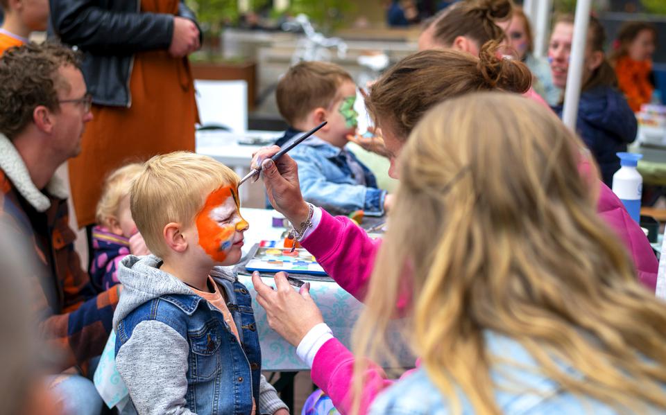 Kinderen laten zich op Koningsdag schminken op het Raadhuisplein in Drachten