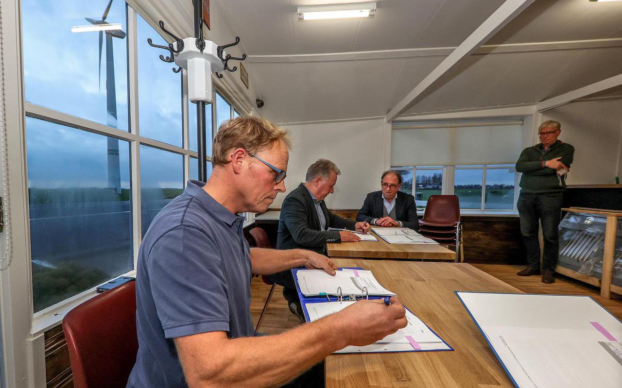 Jarig Jan Boersma van Coöperatie Doarpsmûne Reduzum e.o en Govert Geldof van Tzummer Organisatie voor Energie in de Regio (TOER) ondertekenen het koopcontract in de Blauwe Tent in Reduzum.