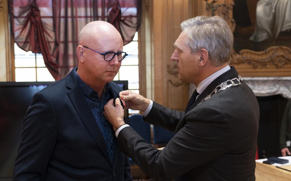 Klaas Visser krijgt de zilveren draagmedaille van het Carnegie Heldenfonds opgespeld door burgemeester Sybrand Buma van Leeuwarden. 