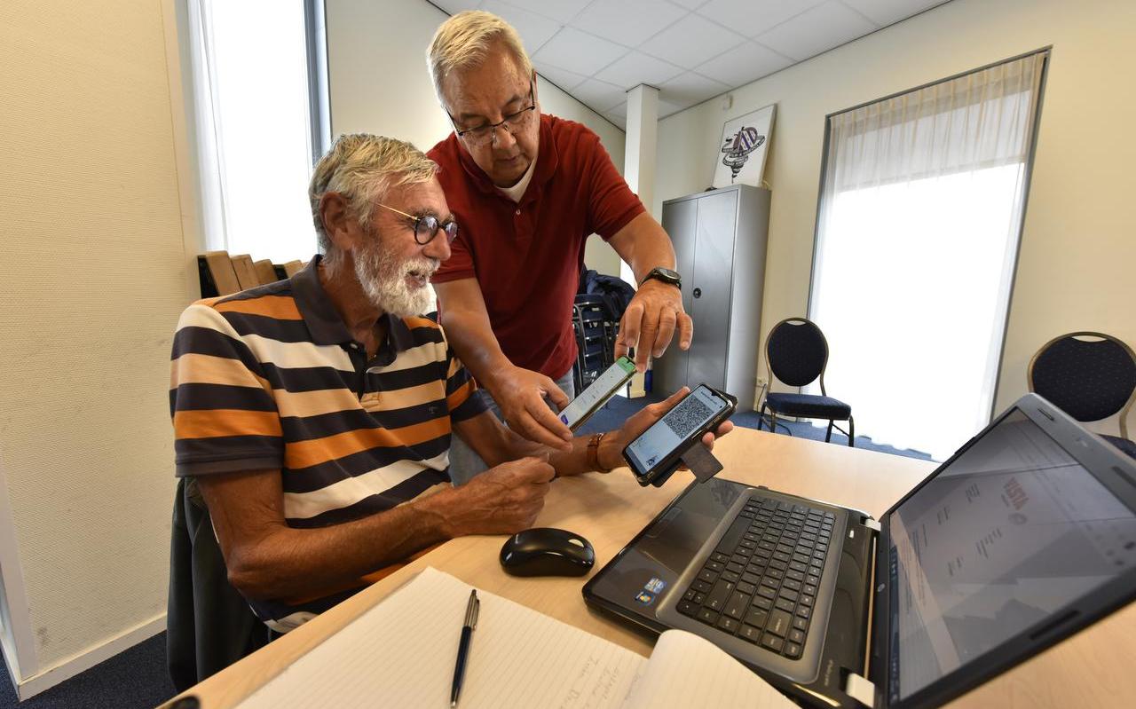 Gabe Westra (79, links) krijt uitleg over de corona-app van Evert Slok Soede. Gabe Westra (79, links) krijt uitleg over de corona-app van Evert Slok Soede.