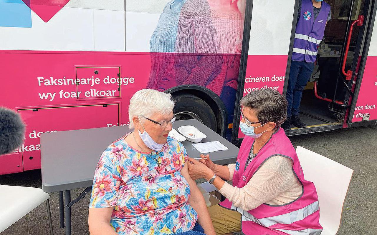 Hilly Kooistra (80) uit Harlingen krijgt de eerste prik bij de vaccinatiebus van GGD Fryslân