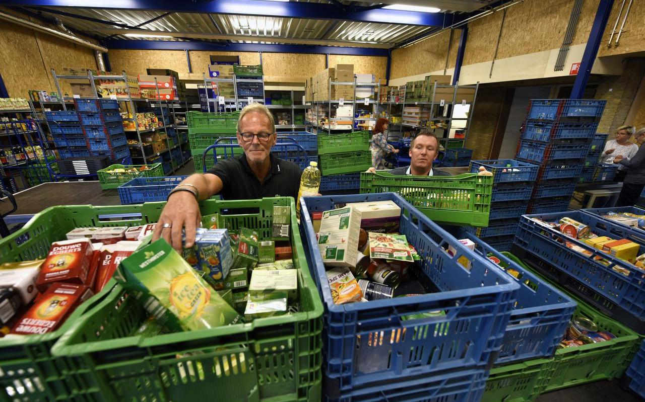 De voedselbank Leeuwarden in betere tijden. Vrijwilligers verdelen voedsel over de kratten.