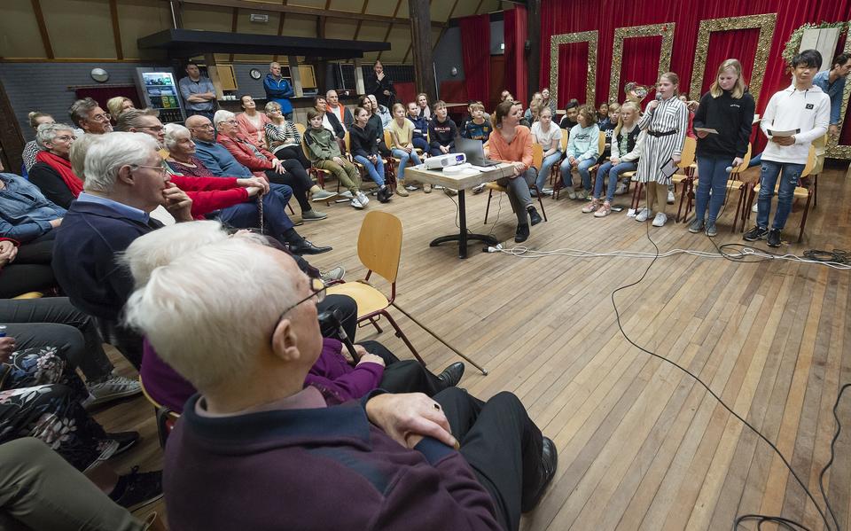 De leerlingen van groep 7 en 8 van OS de Romte in Tytsjerk presenteren hun bevindingen in het kader van project 'Oorlog in mijn Buurt', met op de voorgrond links Oebele Leistra. 