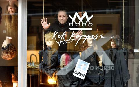 K&K Kappers Leeuwarden doen mee met de stakingsactie. Eigenaar Johan de Wit in de etalage die is vol gezet met kappershoofden.