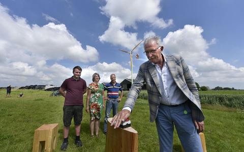 Wethouder Jan Dijkstra zet de eerste boerenwindmolen van Fryslân in werking op het bedrijf van (vanaf links) Sietse de Boer en Wietske en Germ de Boer. 