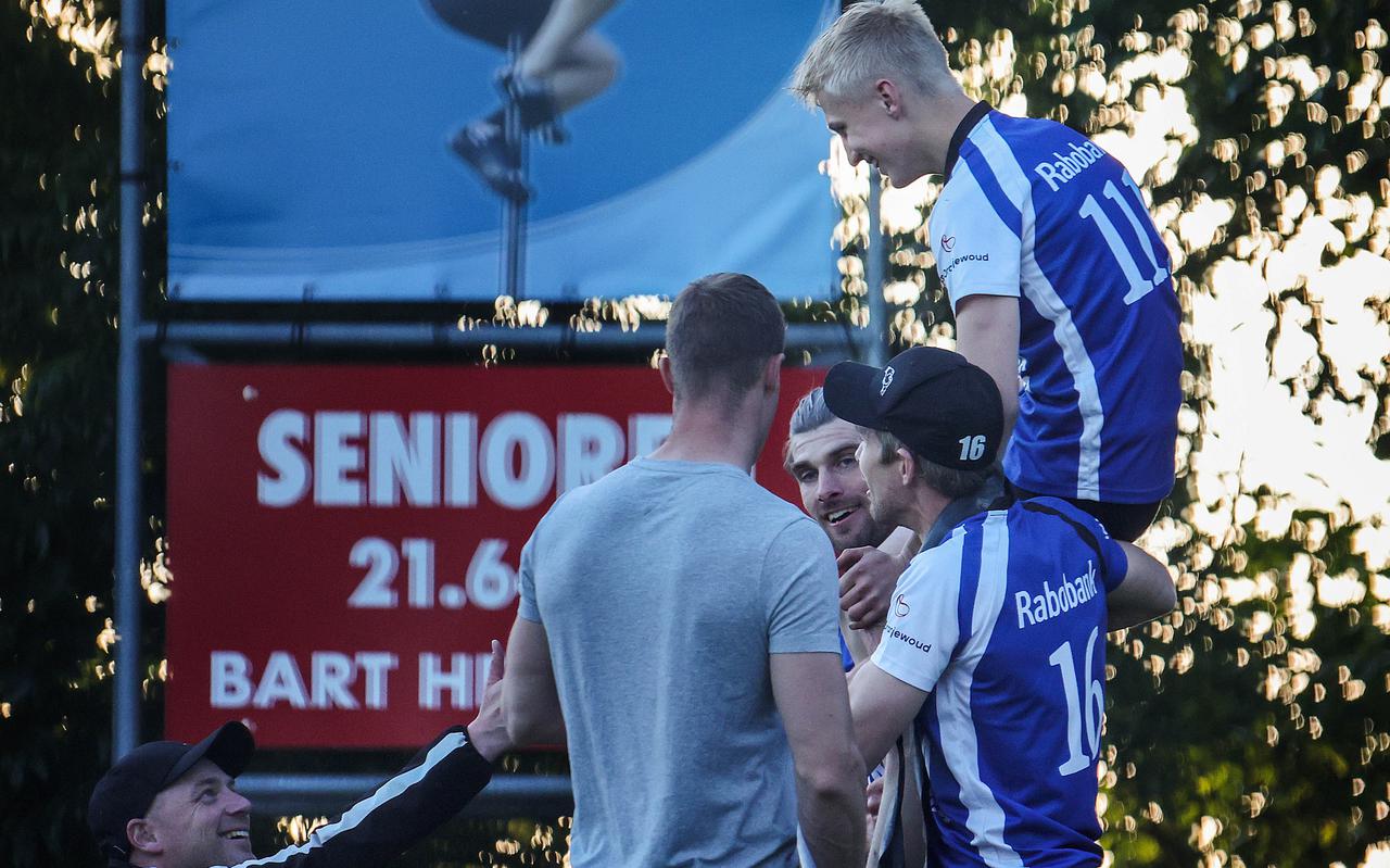Junior Germ Terpstra gaat na zijn 19,22 metersprong op de schouders bij Ysbrand en Oane Galama (16) en krijgt de felicitaties van seniorenwinnaar Nard Brandsma (op de rug gezien). 