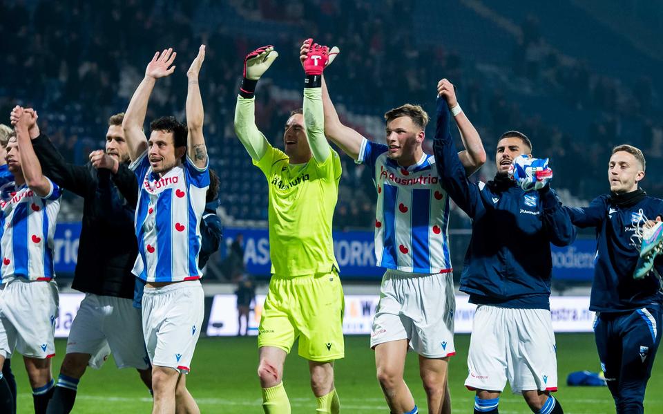 De spelers van sc Heerenveen vieren de overwinning op Volendam, met de hoofdrolspelers Xavier Mous en Sydney van Hooijdonk (r) hand in hand. 
