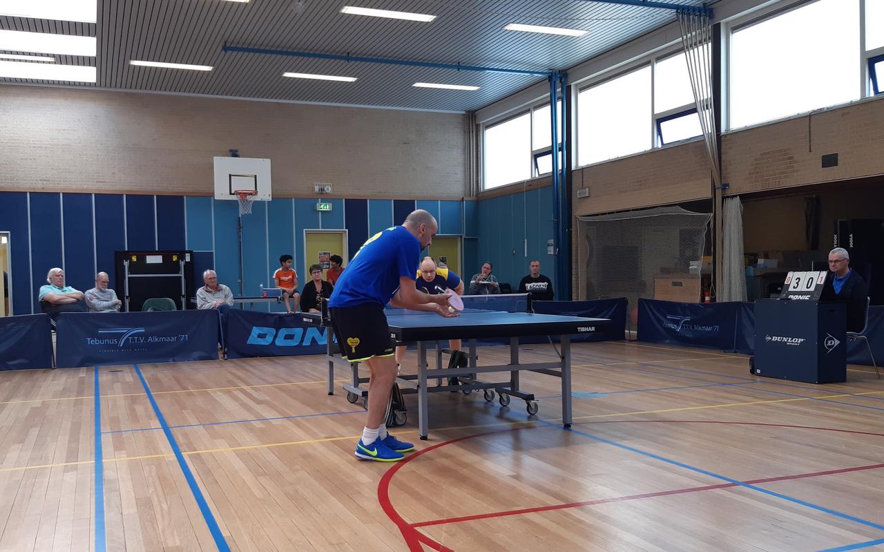 Peter Verweij van TTV Buitenpost, achter de tafel, in het gewonnen duel met John Scott (voorgrond0 van koploper Ping Pong Alkmaar. 